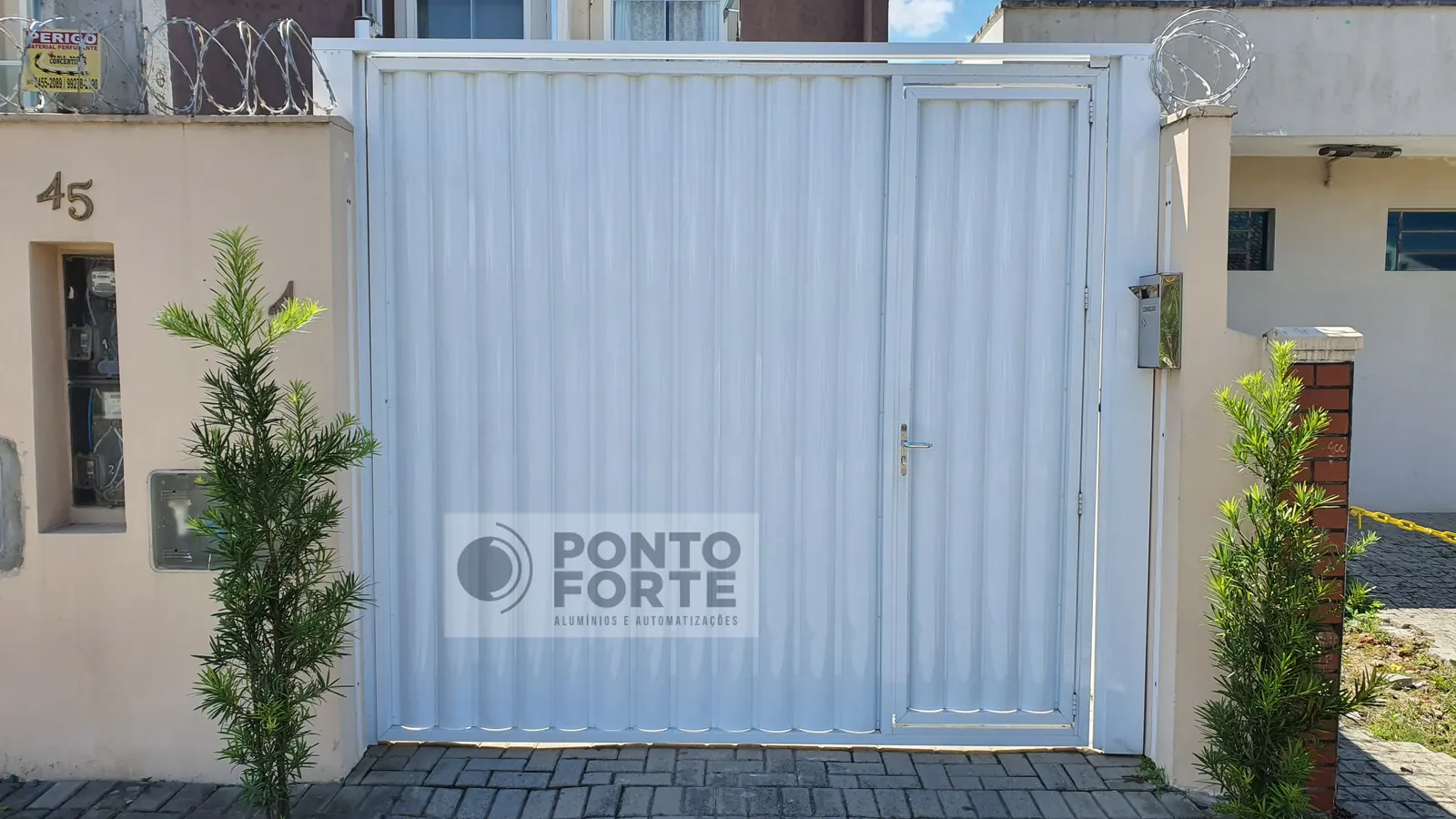 Portão basculante de alumínio branco em chapa corrugada, com portão social no mesmo quadro, sob medida para o vão, em Joinville