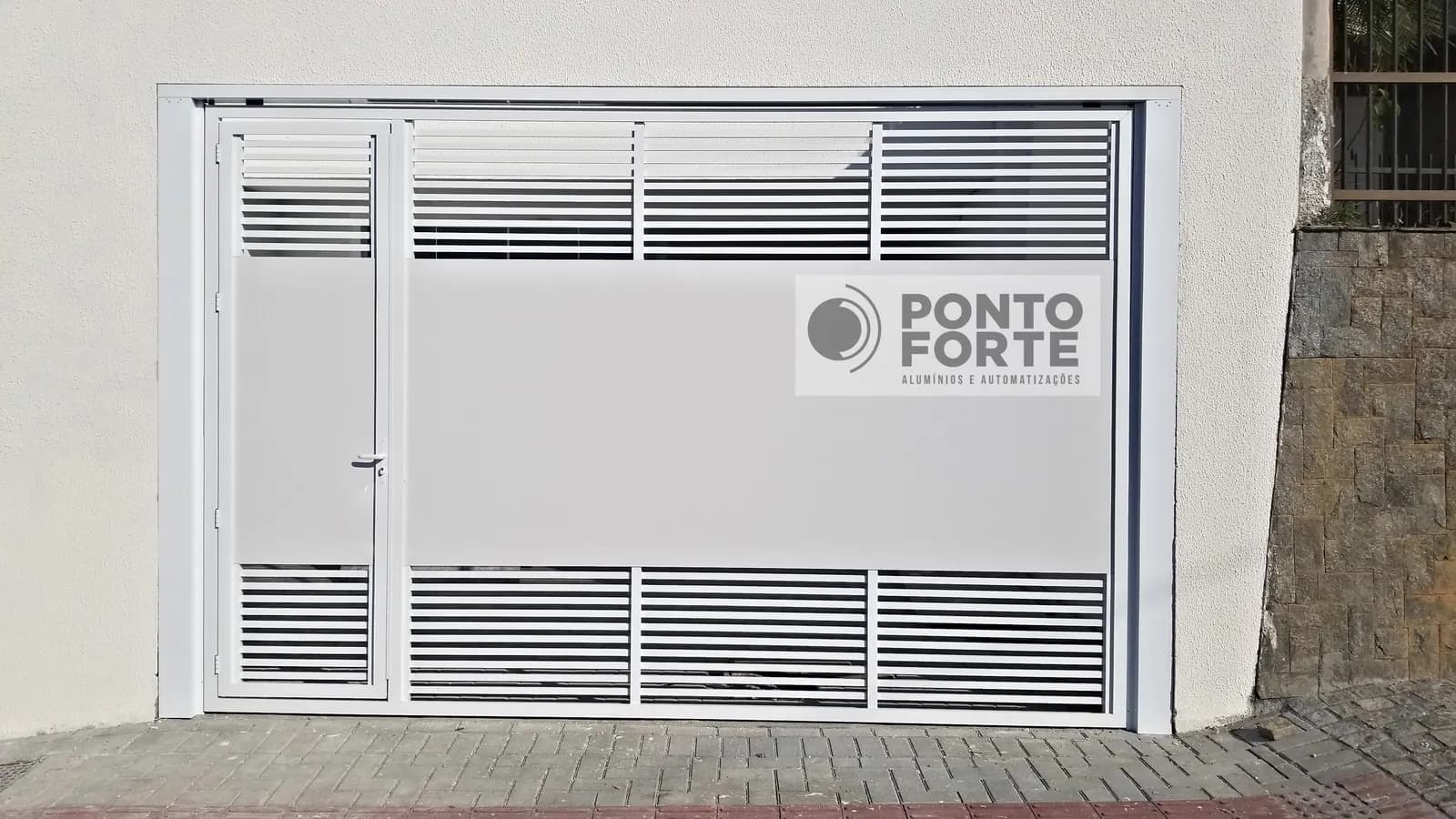 Portão basculante de alumínio branco fechado no centro e vazado em cima e embaixo, com portão social no mesmo quadro, sob medida para o vão