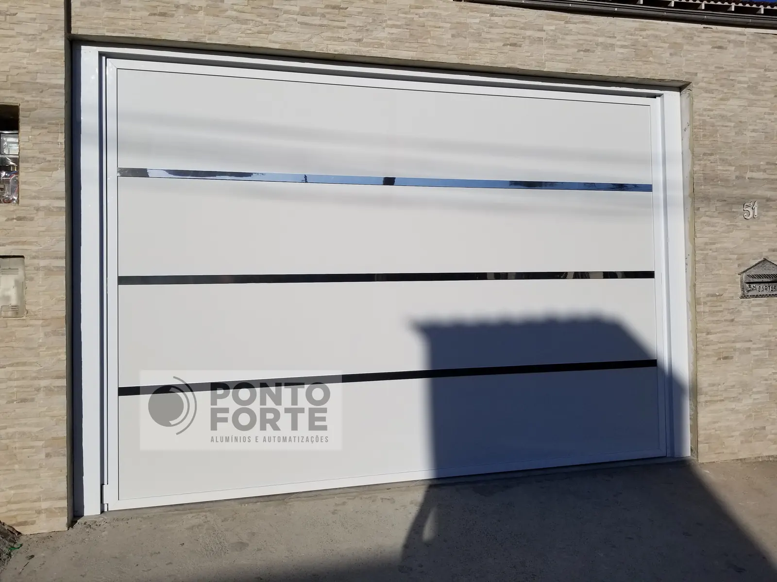 Portão basculante de alumínio branco liso com faixas cromadas, fabricado e instalado pela Ponto Forte