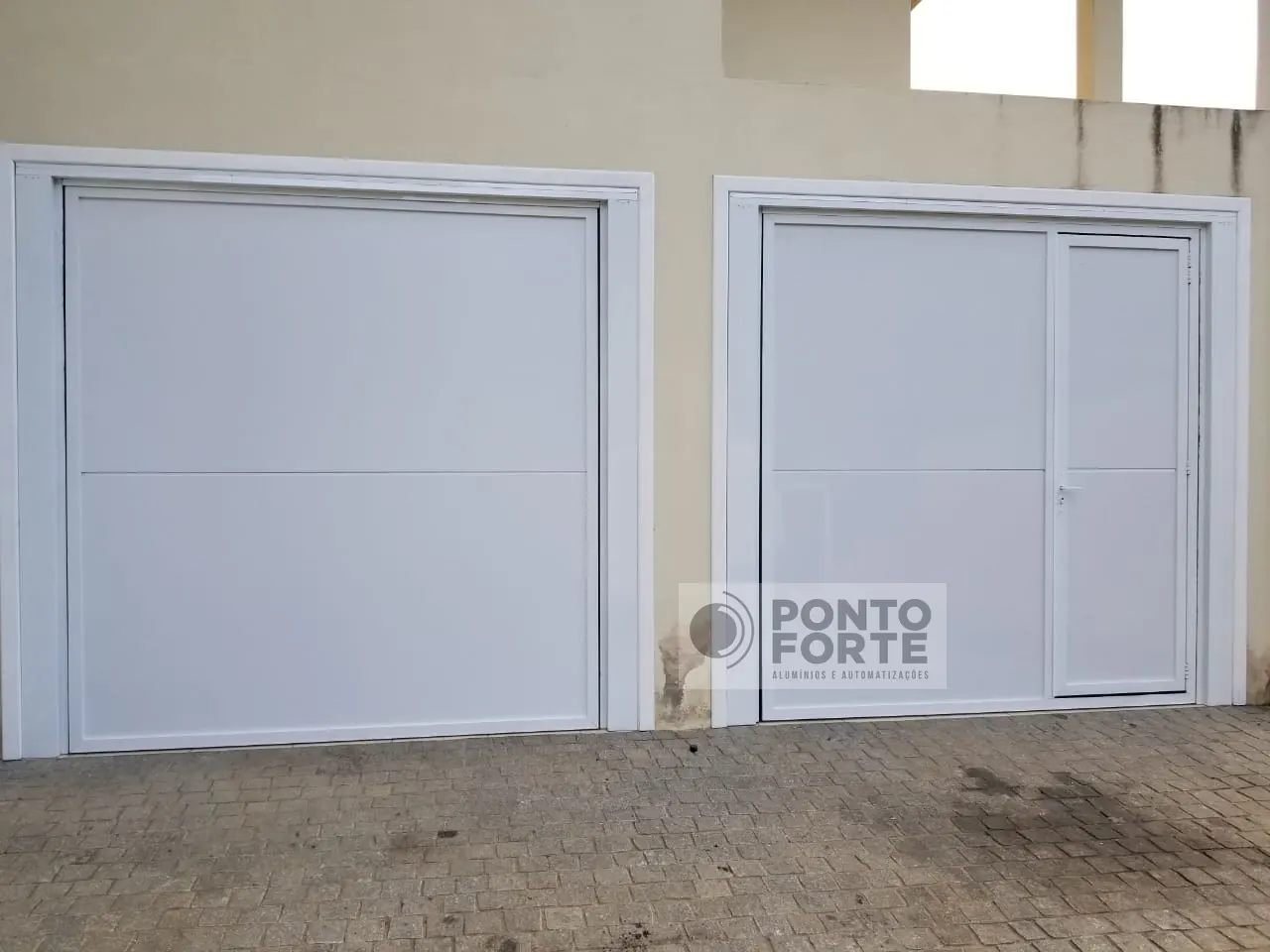 Projeto entregue pela Ponto Forte, portão basculante de alumínio branco liso, com portão social no mesmo quadro