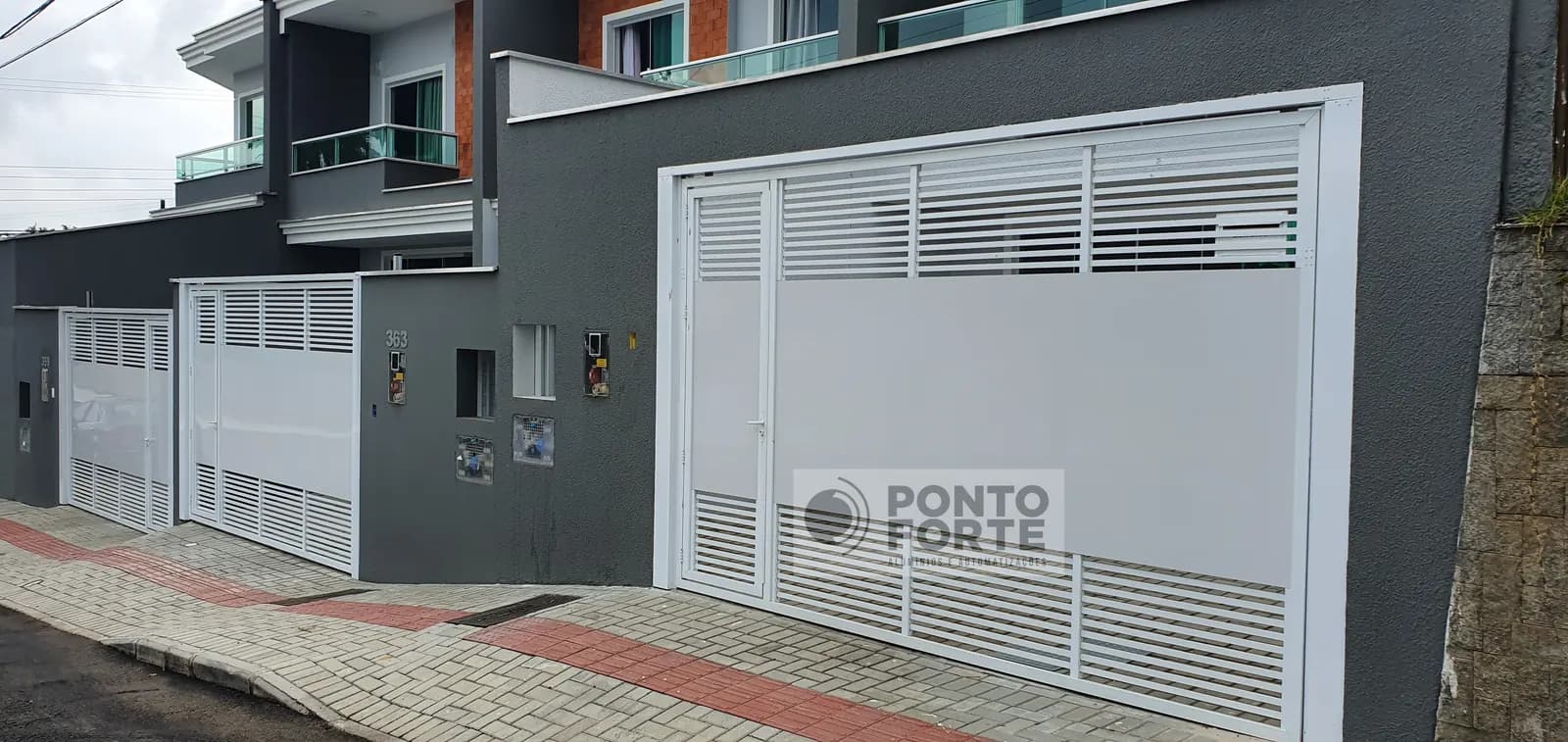 Portão basculante de alumínio branco vazado com barras horizontais, com portão social no mesmo quadro, em residência