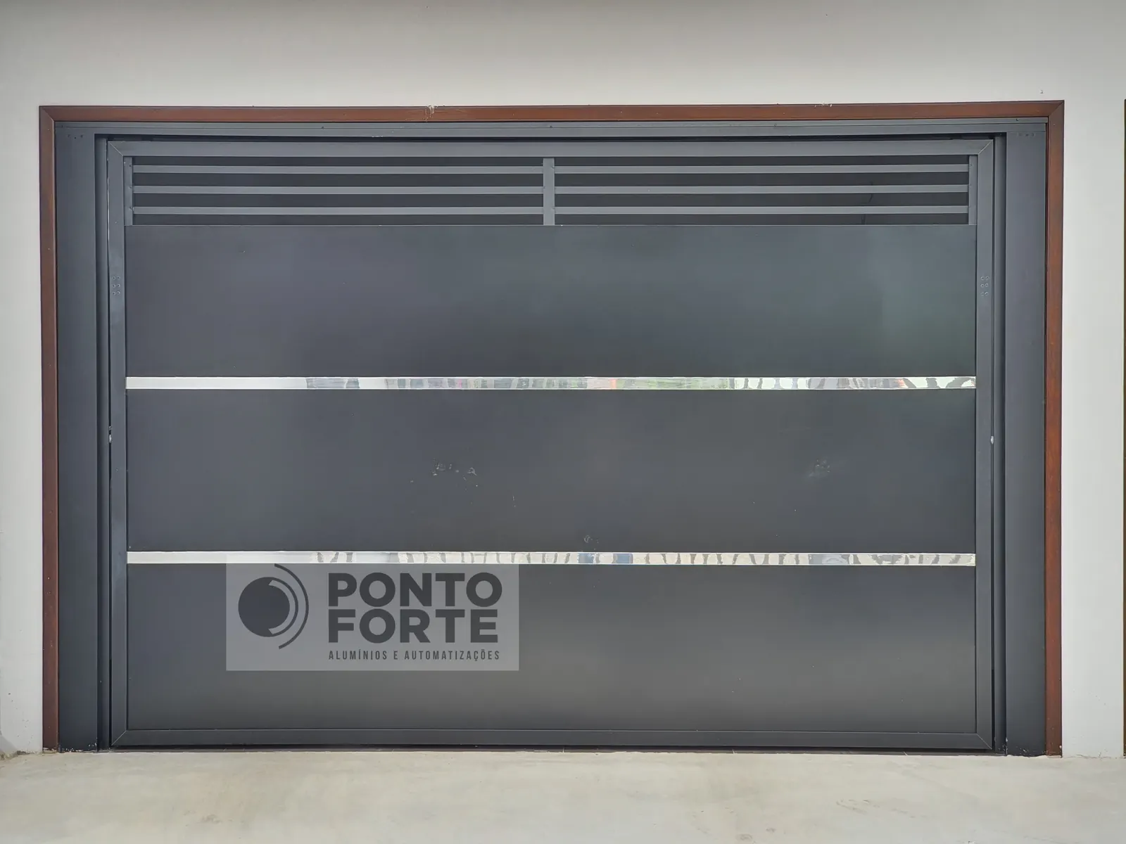 Projeto entregue pela Ponto Forte, portão basculante de alumínio preto fechado no centro e vazado em cima e embaixo, em Joinville