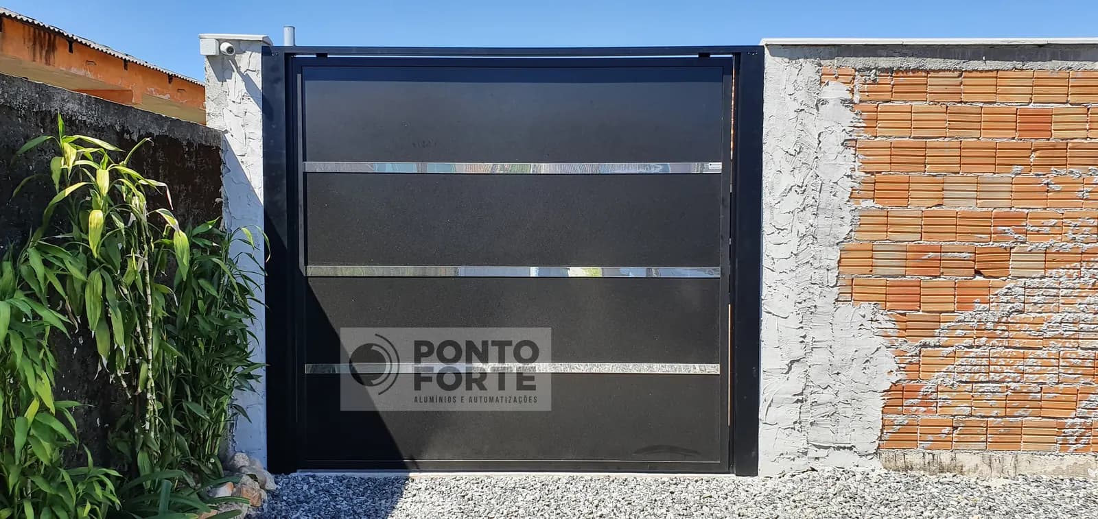 Portão basculante de alumínio preto liso com faixas cromadas, em residência