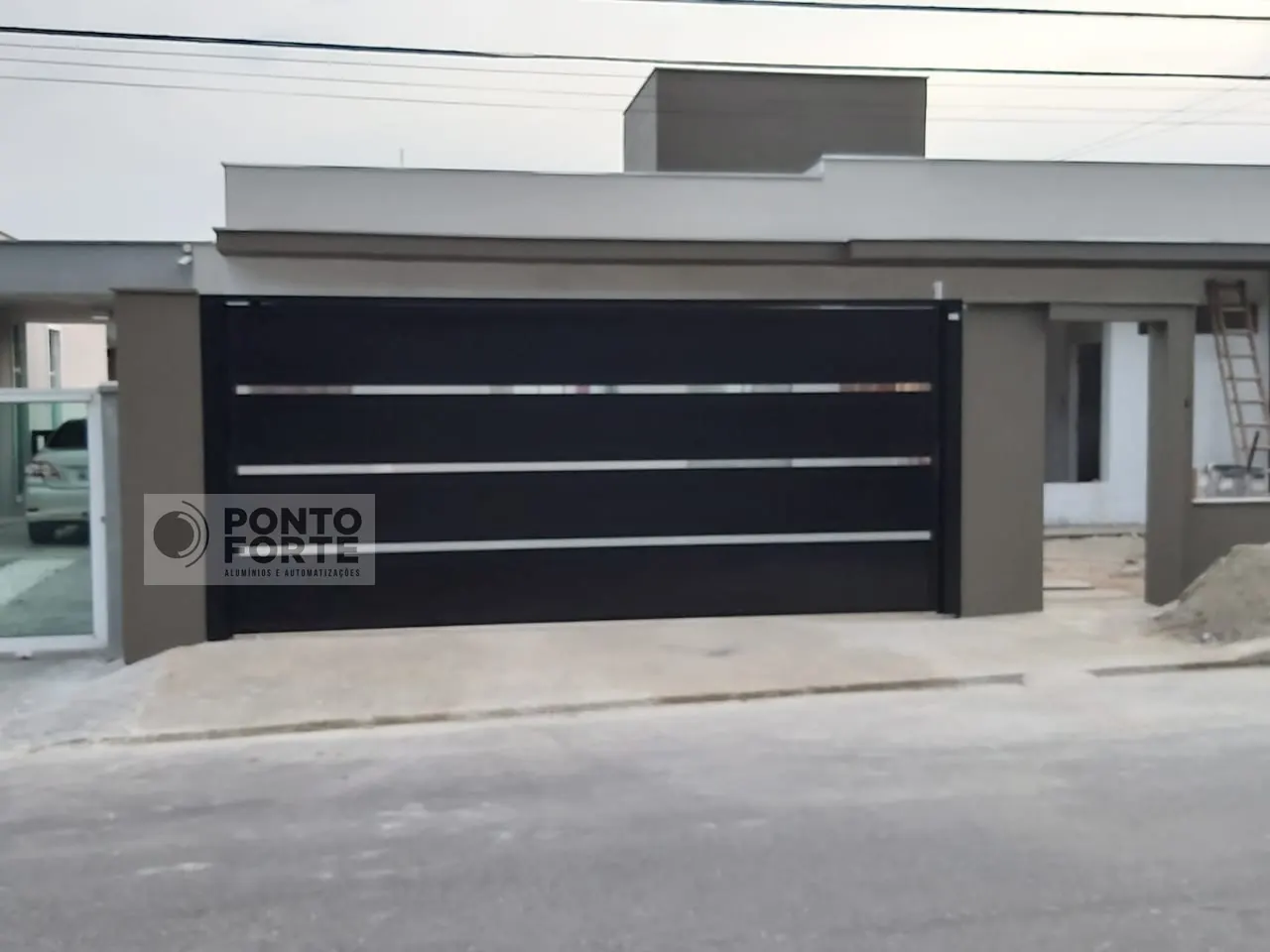 Portão basculante de alumínio preto liso com faixas cromadas, em residência