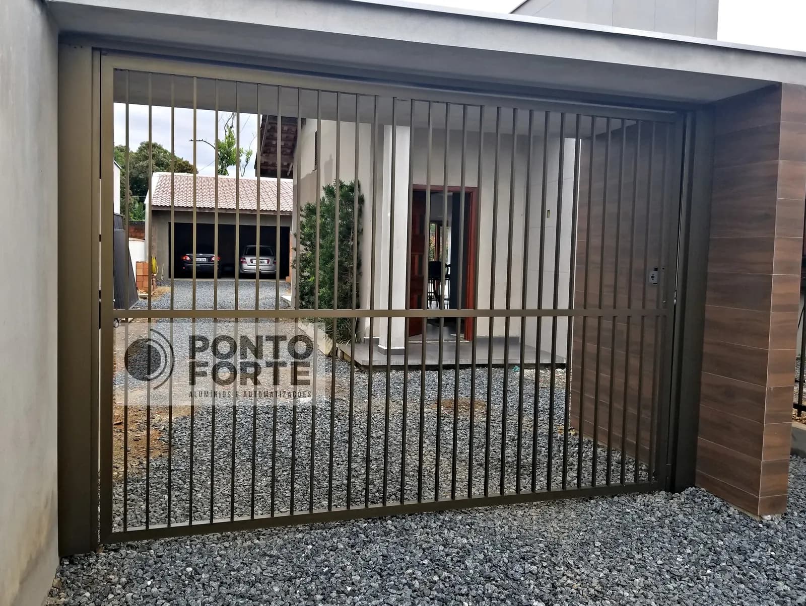 Projeto entregue pela Ponto Forte, portão basculante de alumínio preto vazado com barras verticais