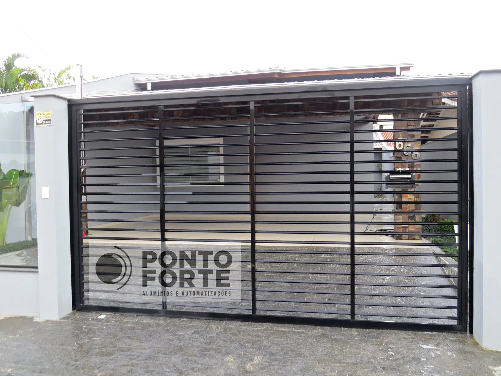 Projeto entregue pela Ponto Forte, portão basculante de alumínio preto vazado com barras horizontais