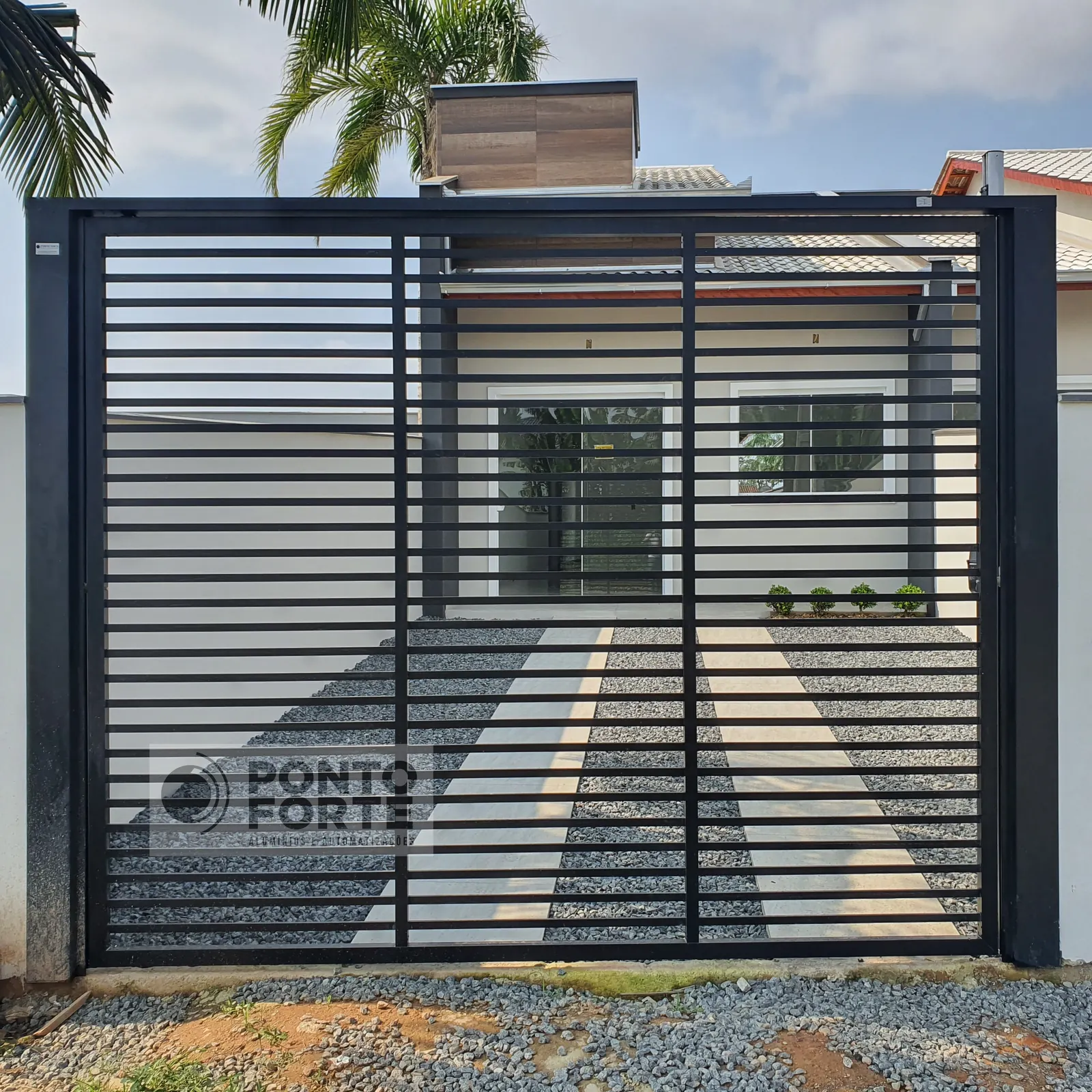 Portão basculante de alumínio preto vazado com barras horizontais, em residência