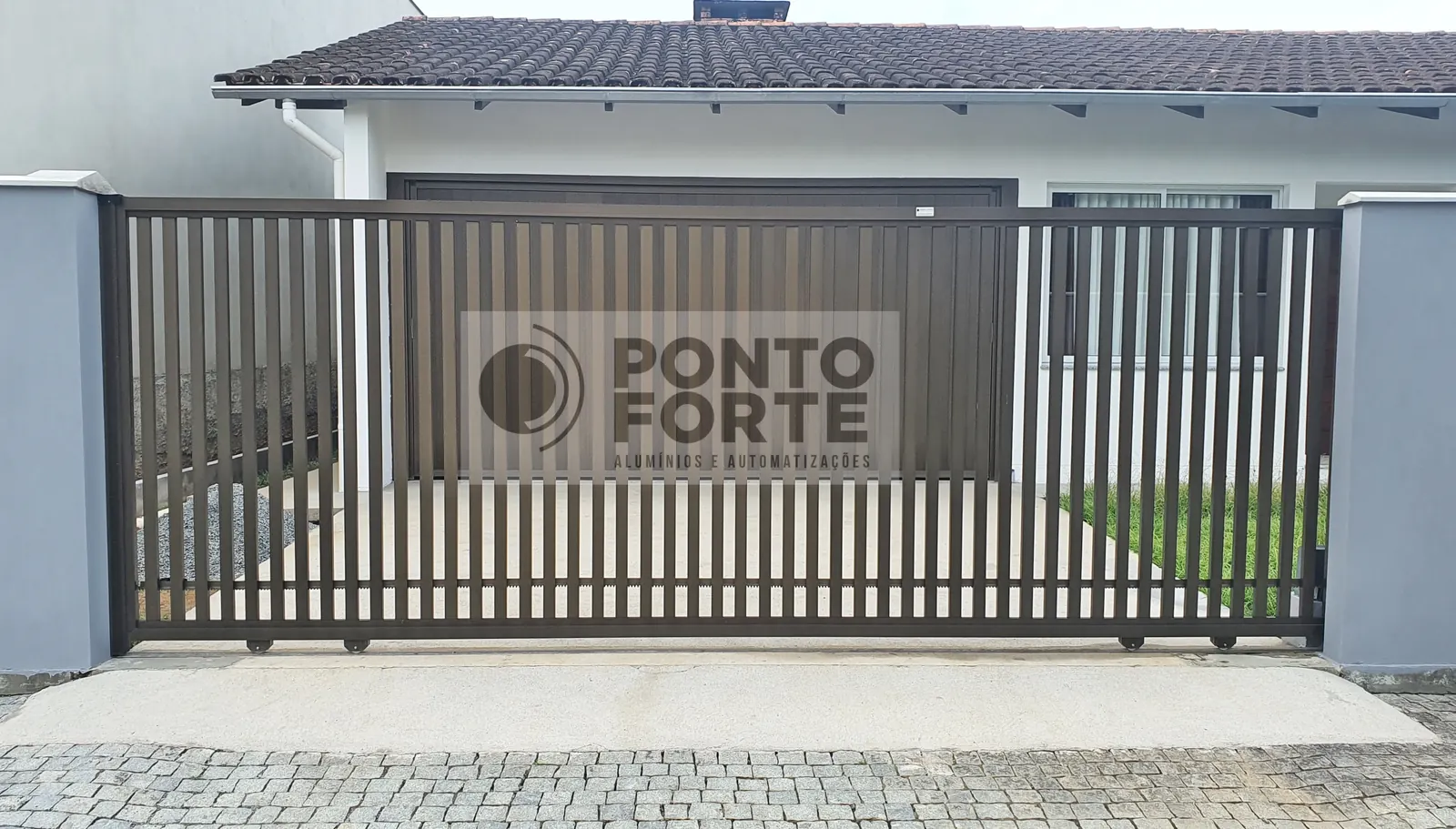 Portão de correr de alumínio bronze vazado com barras verticais, em residência, em Joinville