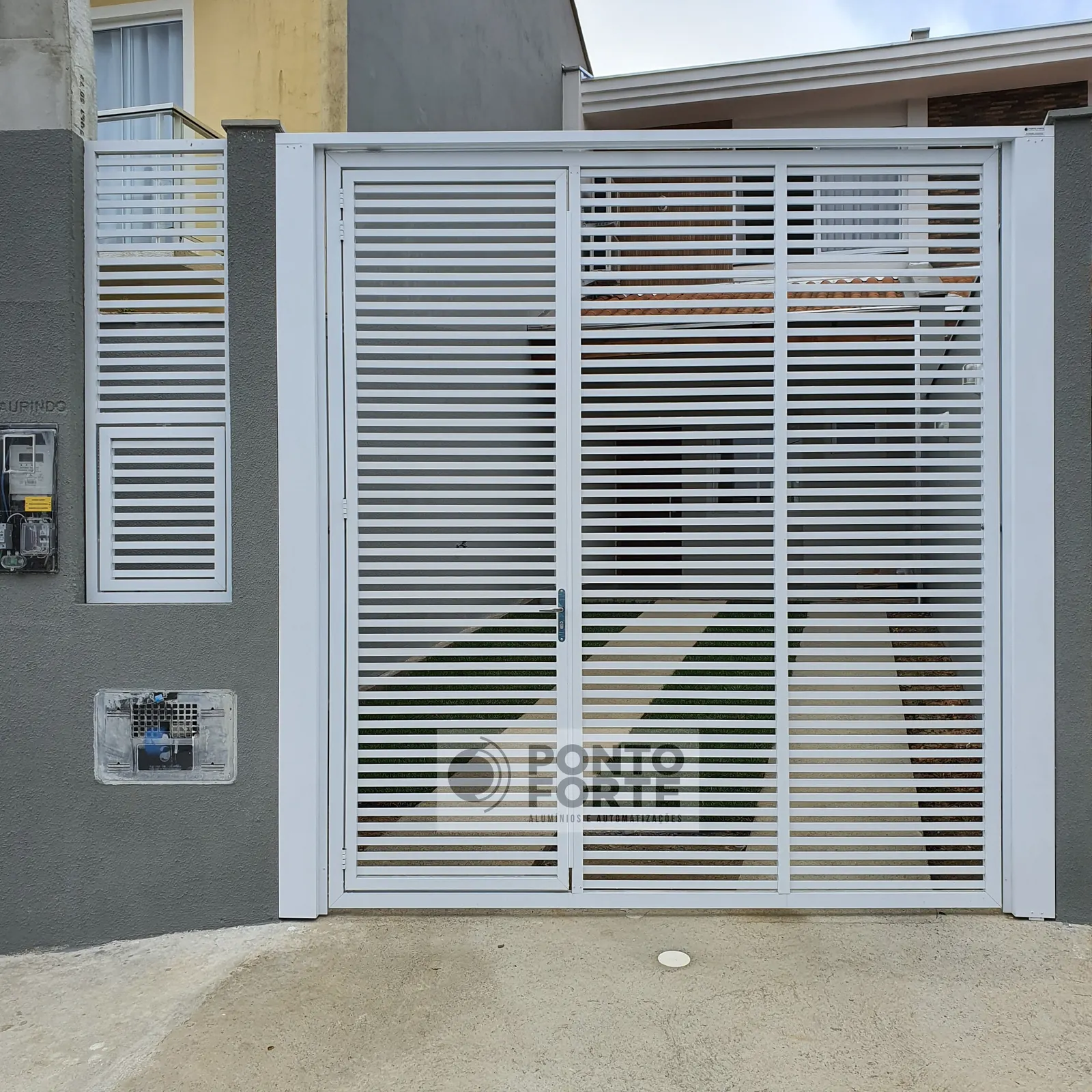 Portão basculante de alumínio branco vazado com barras, com portão social no mesmo quadro, modelo que fabricamos e instalamos em Campo Alegre