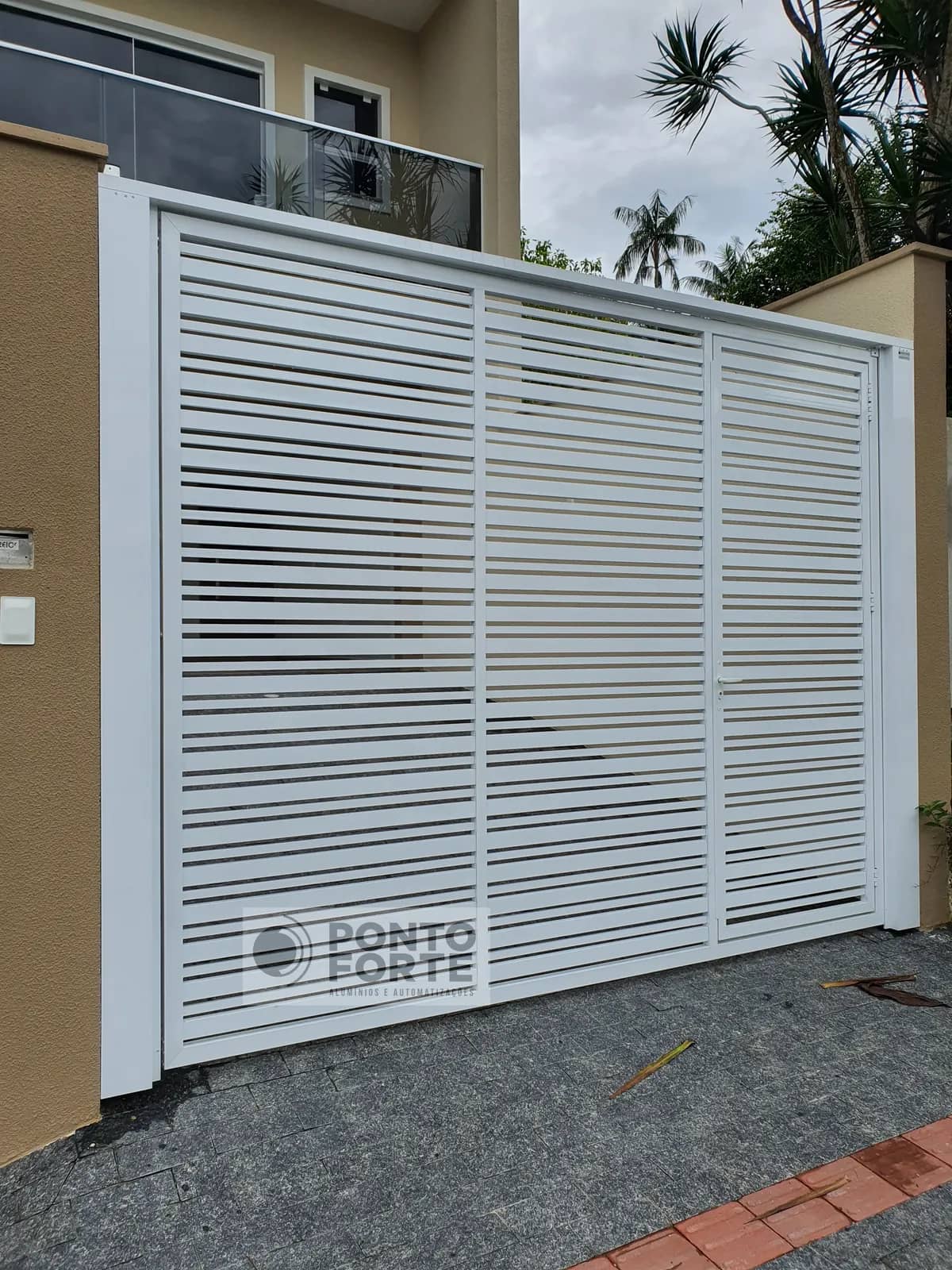 Portão basculante de alumínio branco vazado com barras, modelo que fabricamos e instalamos em Rio Negrinho