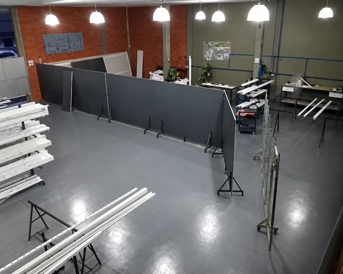 Interior da fábrica da Ponto Forte em Joinville, com perfis de alumínio e portões em fabricação