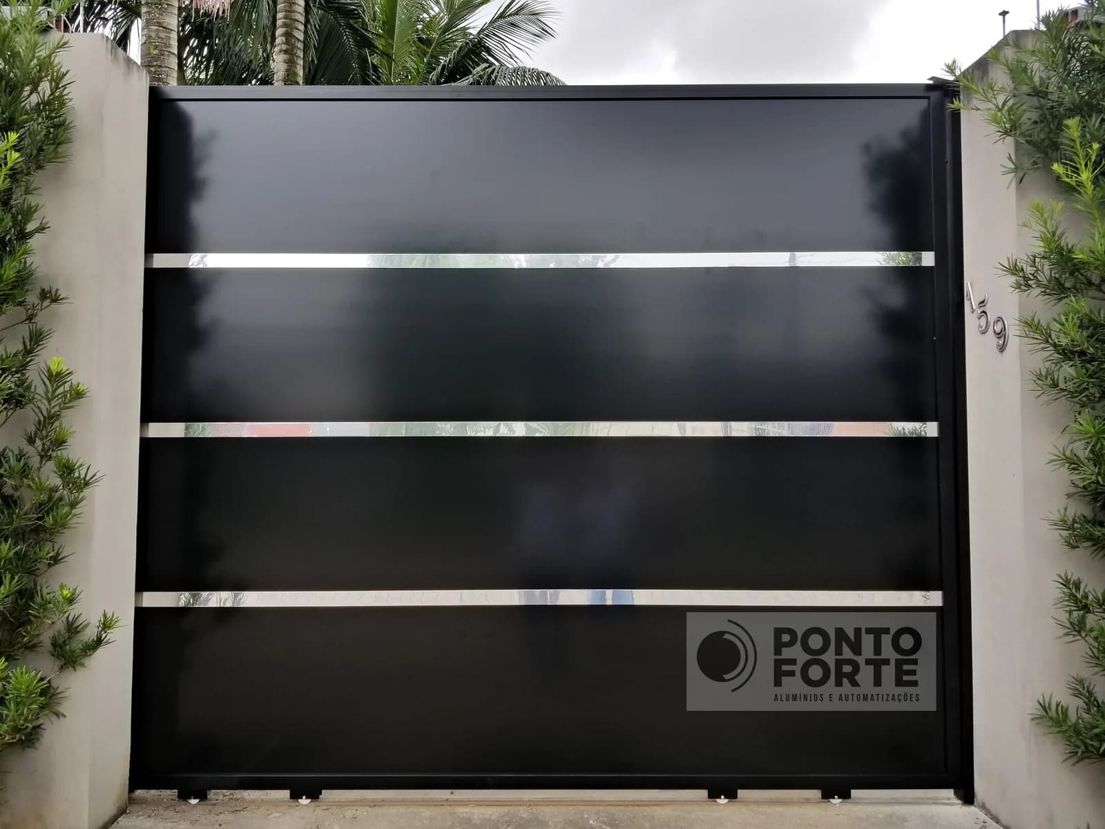 Portão de correr de alumínio preto em chapa lisa com três faixas cromadas horizontais, em residência em Joinville