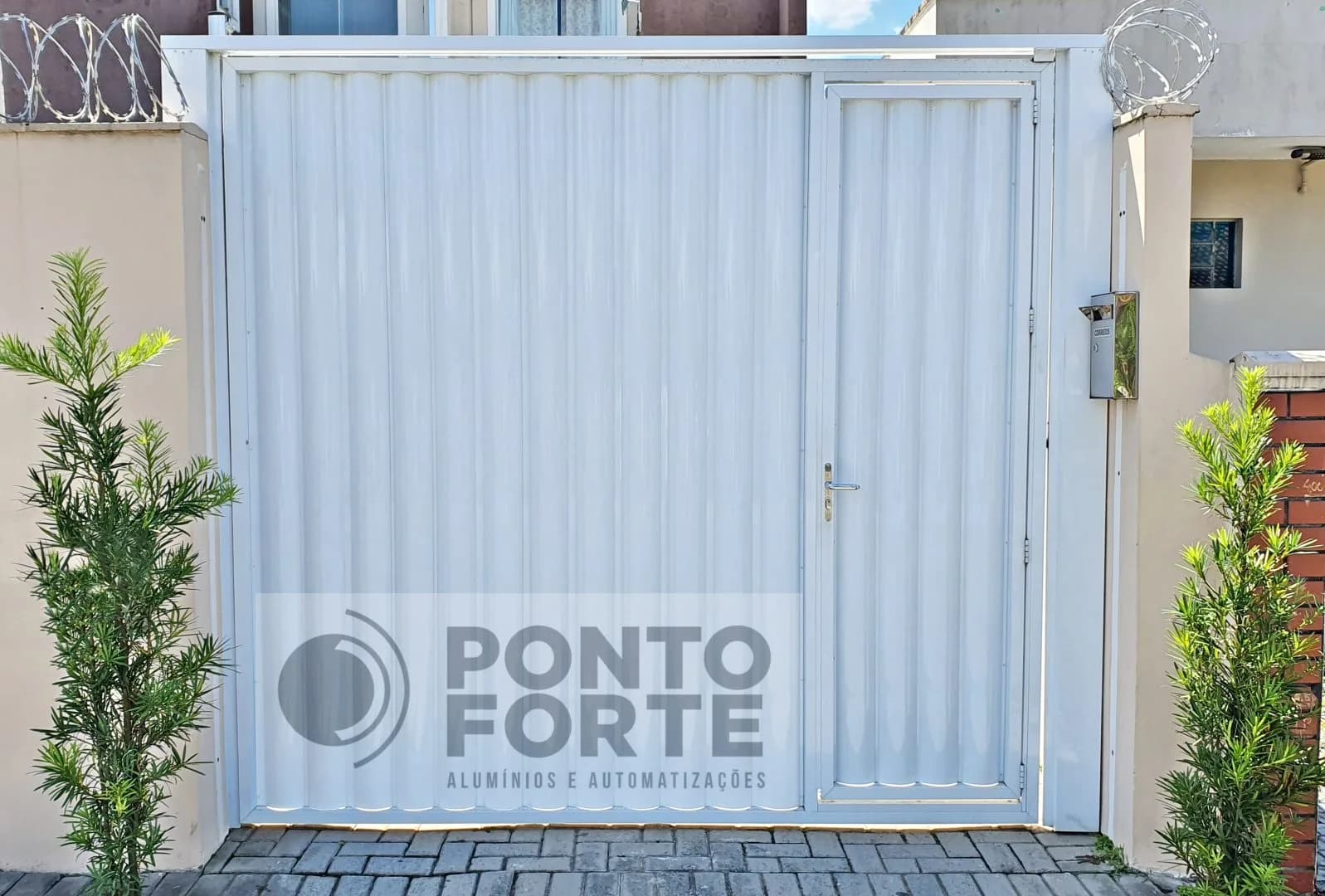 Portão basculante de alumínio branco em lambril frisado com portão social no mesmo quadro