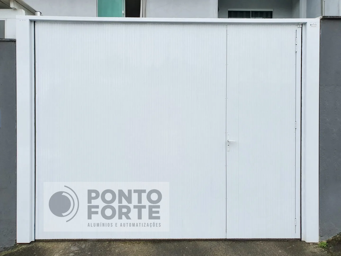 Portão basculante de alumínio branco em lambril frisado, sem faixas, em muro de residência