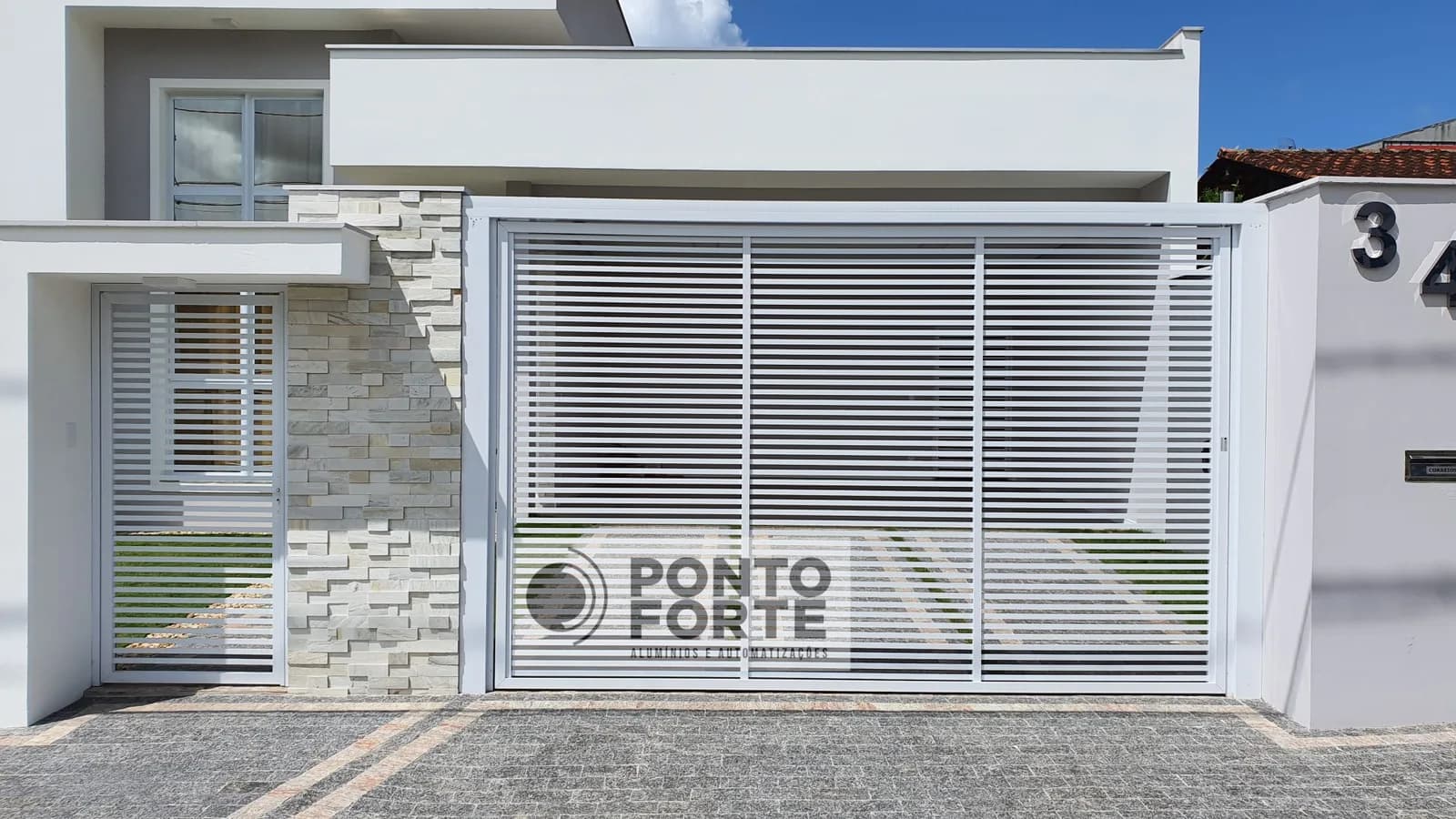 Portão basculante de alumínio branco vazado com barras, com portão social ao lado em vão próprio, no mesmo acabamento