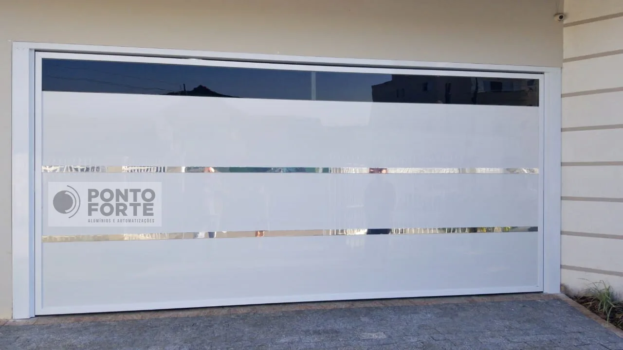 Portão basculante de alumínio branco com abertura transparente escura no topo e faixas cromadas, em garagem dupla
