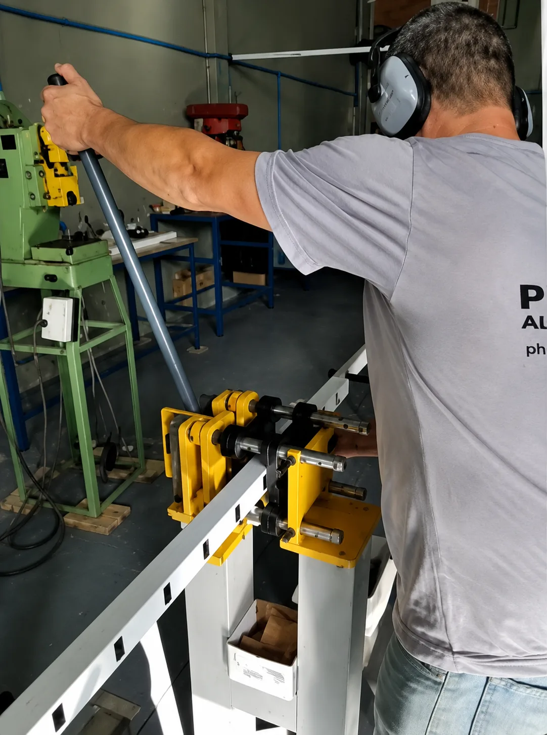 Colaborador da Ponto Forte usinando um perfil de alumínio de portão basculante na fábrica em Joinville