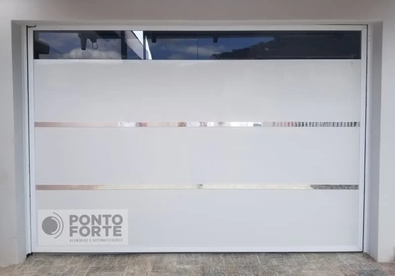 Portão de garagem de alumínio branco liso com faixas cromadas e faixa transparente no alto, visto de frente