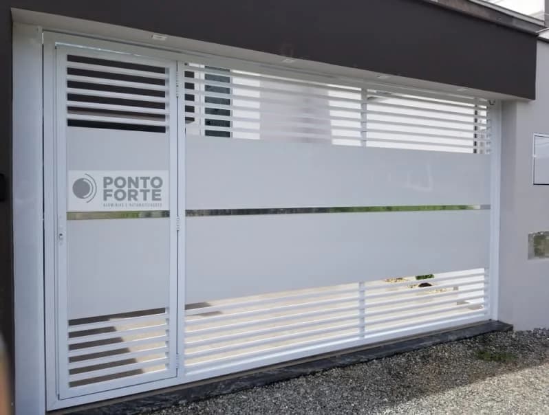 Portão de garagem de alumínio branco fechado no centro com porta social embutida no mesmo quadro