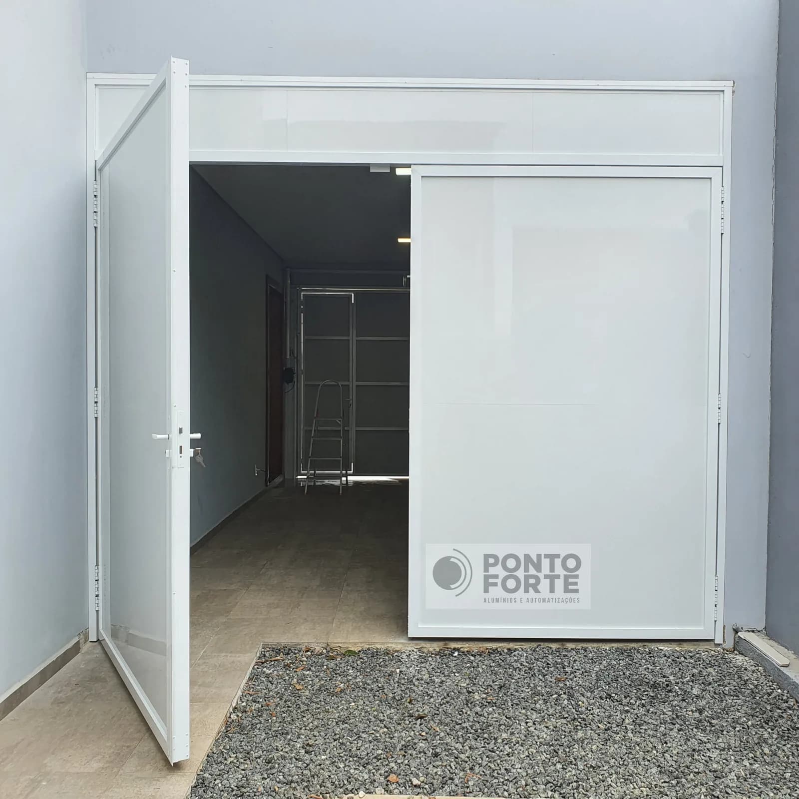 Portão de abrir de alumínio branco liso com uma das folhas aberta, mostrando o giro da folha